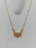 A gold chain necklace with a semi-circular pendant paved with small clear stones and featuring small gold spikes along the curved top edge, displayed on a white mannequin bust against a light gray background.
