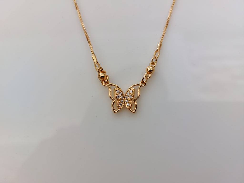 A gold butterfly pendant necklace with a small cluster of clear stones in the center, displayed on a plain light gray background.